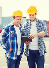 Image showing smiling builders in hardhats with tablet pc