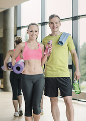 Image showing smiling couple with water bottles in gym