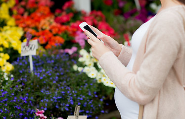 Image showing pregnant woman with smartphone at flower market