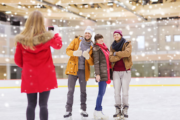 Image showing happy friends taking photo on skating rink