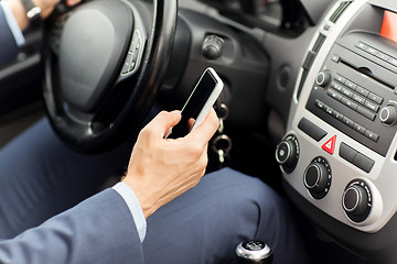 Image showing close up of man hand with smartphone driving car