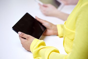 Image showing close up of female hands with tablet pc at table