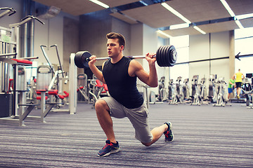 Image showing young man flexing muscles with barbell in gym