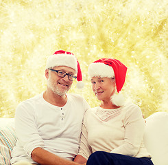 Image showing happy senior couple in santa helper hats