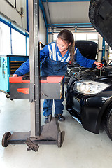 Image showing Mechanic, adjusting the hight of a car\'s head lights