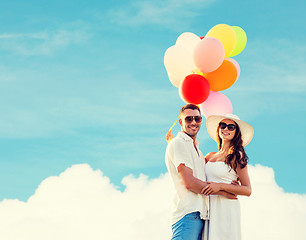 Image showing smiling couple with air balloons outdoors