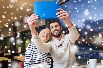 Image showing happy couple with tablet pc taking selfie at cafe