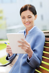 Image showing businesswoman reading notes in notepad outdoors