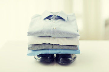 Image showing close up of folded male shirts and shoes on table