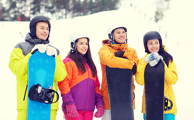 Image showing happy friends in helmets with snowboards