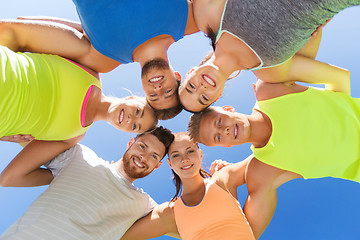 Image showing group of happy sporty friends in circle outdoors