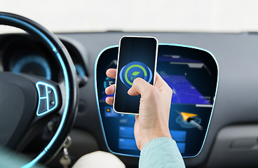 Image showing man driving car and setting eco mode on smartphone