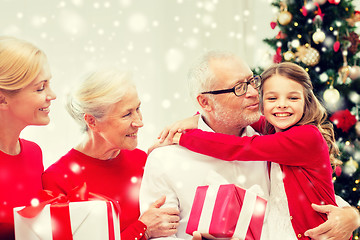 Image showing smiling family with gifts at home