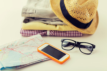 Image showing close up of summer clothes and travel map on table