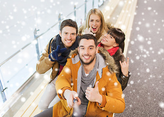 Image showing happy friends taking selfie on skating rink