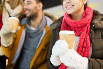 Image showing happy friends with coffee cups on skating rink