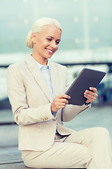 Image showing smiling businesswoman with tablet pc outdoors