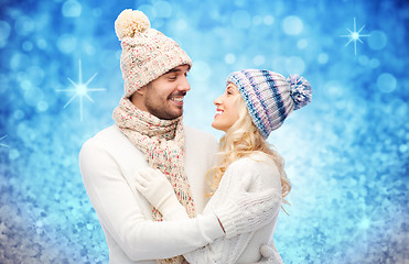 Image showing happy couple in winter clothes hugging over lights