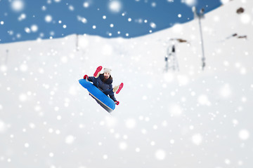 Image showing happy teenage girl sliding down on snow tube