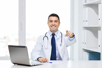 Image showing smiling doctor pointing finger at you in office