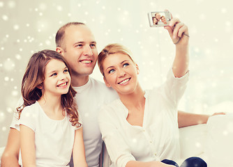 Image showing happy family with camera taking picture at home