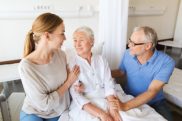 Image showing happy family visiting senior woman at hospital