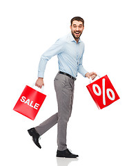 Image showing smiling man walking with red shopping bag