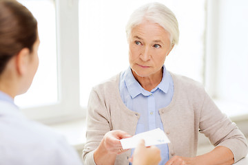 Image showing doctor giving prescription to senior woman