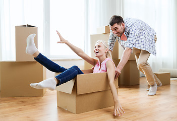 Image showing couple with cardboard boxes having fun at new home