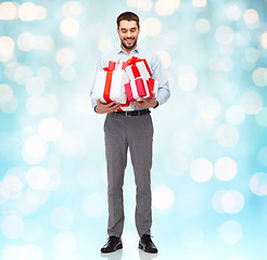 Image showing happy young man holding gift boxes