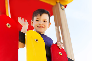 Image showing happy little boy climbing on children playground