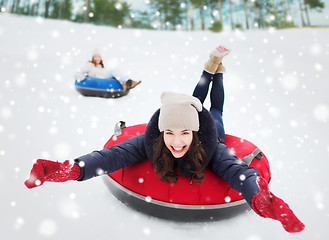 Image showing group of happy friends sliding down on snow tubes