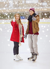 Image showing happy couple holding hands on skating rink