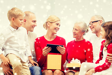 Image showing smiling family with tablet pc and gift box at home