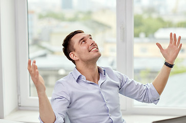 Image showing happy businessman with laptop in office