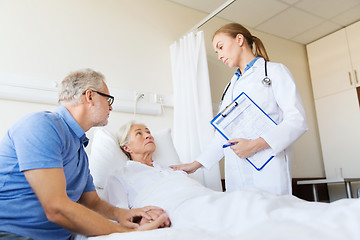 Image showing senior woman and doctor with clipboard at hospital