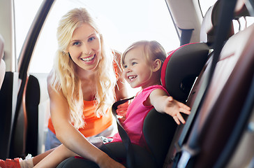 Image showing happy mother fastening child with car seat belt