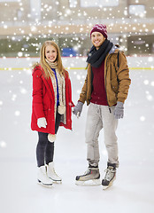 Image showing happy couple holding hands on skating rink