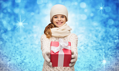 Image showing girl in hat, muffler and gloves with gift box