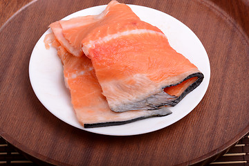 Image showing Raw salmon fish steaks with fresh herbs on white plate