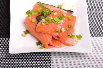 Image showing Salted salmon fillet with parsley leaf on the white bowl