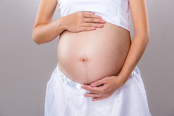 Image showing Belly of pregnant woman with gray background