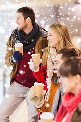 Image showing happy friends with coffee cups on skating rink