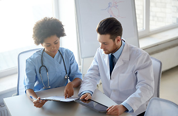 Image showing doctors with tablet pc and clipboard at hospital