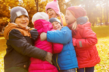 Image showing group of happy children hugging in autumn park