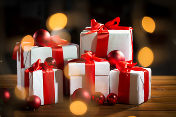 Image showing gift boxes and red christmas balls on wooden floor