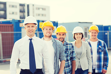 Image showing group of smiling builders in hardhats outdoors