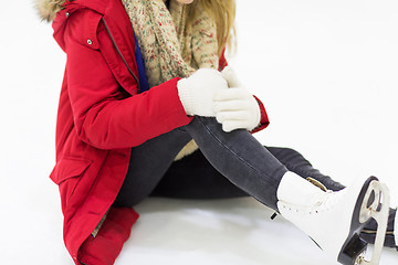 Image showing young woman with knee trauma on skating rink