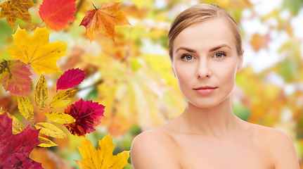 Image showing beautiful young woman face over autumn leaves