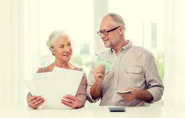 Image showing senior couple with money and calculator at home